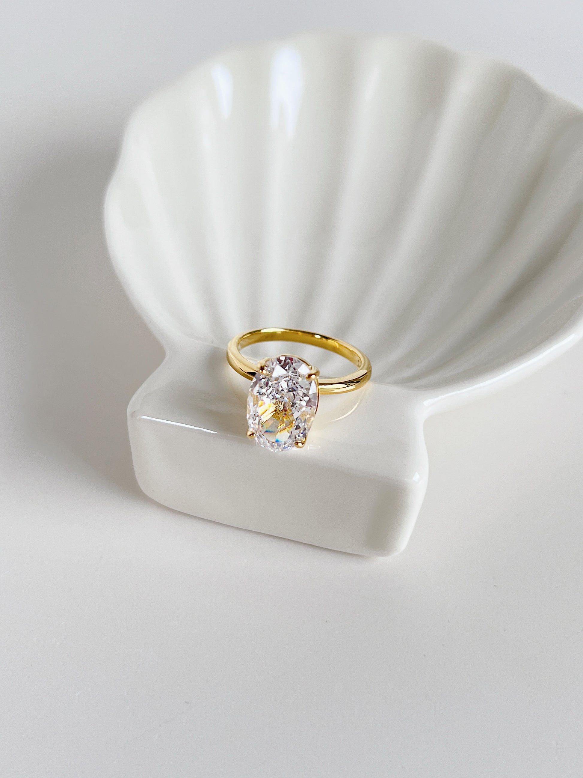 High shine editorial oval solitaire ring with four prong setting