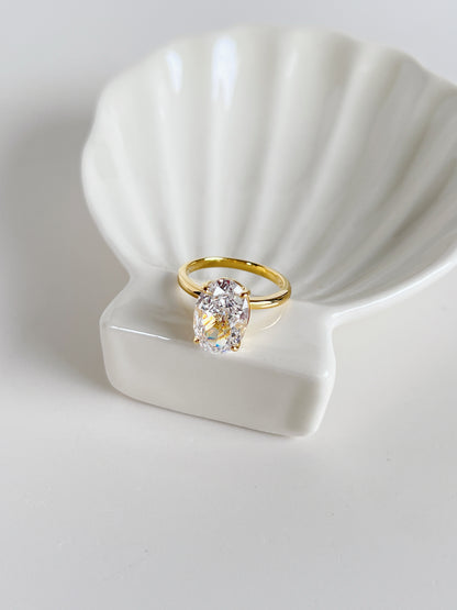 High shine editorial oval solitaire ring with four prong setting