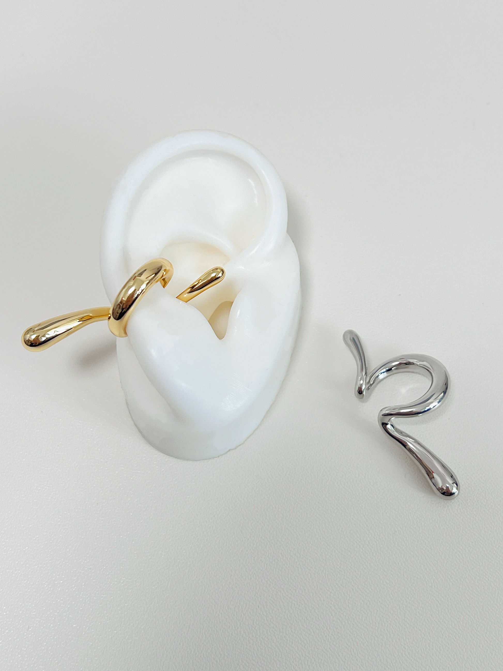Close-up of white's silicone ear with the gold Parker cuff for a minimalist stack.