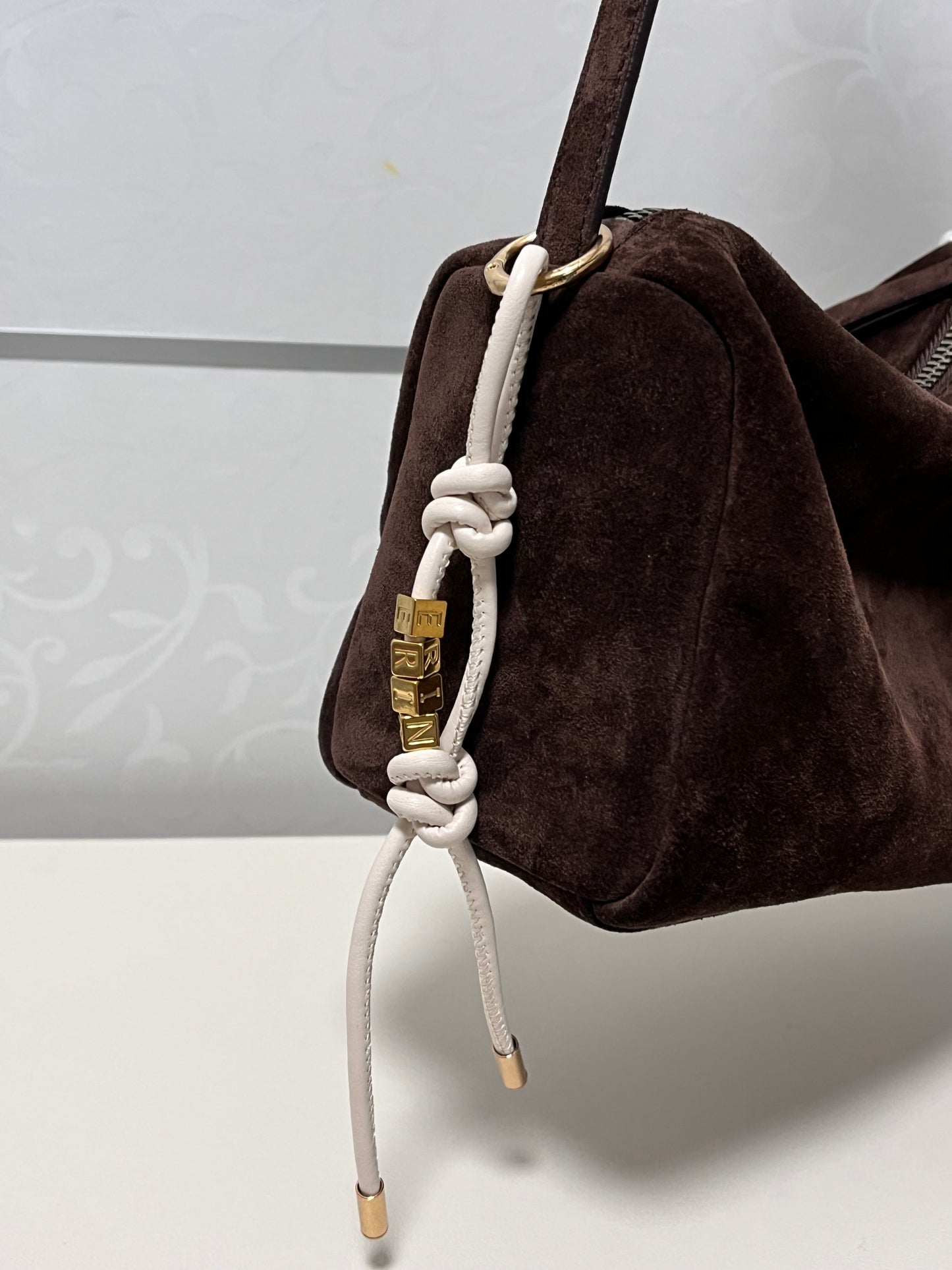 White leather personalized initial bag charm.