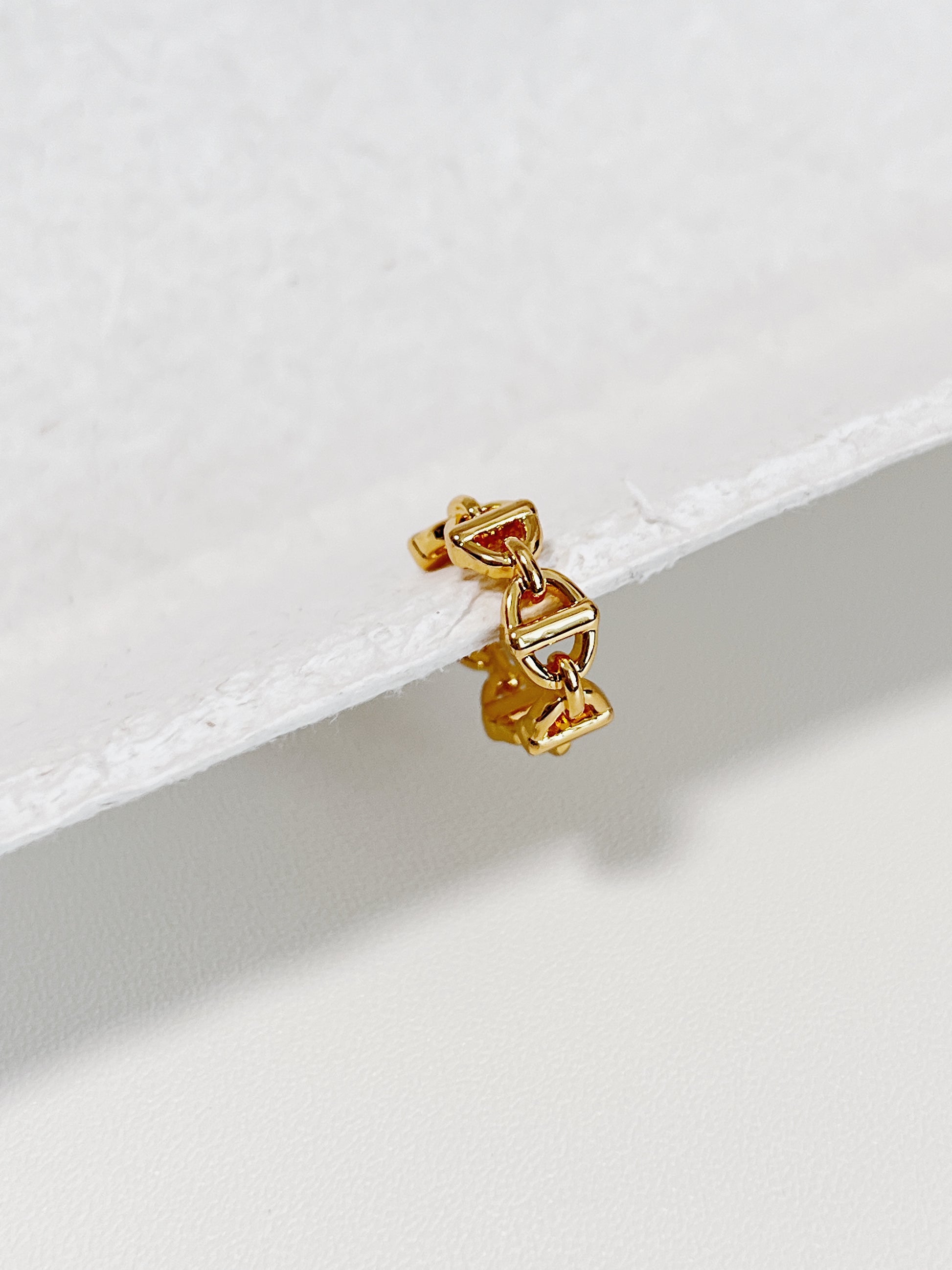 Macro of gold Windsor Link Ear Cuff showing the interlocking nautical motif and 18K PVD finish.
