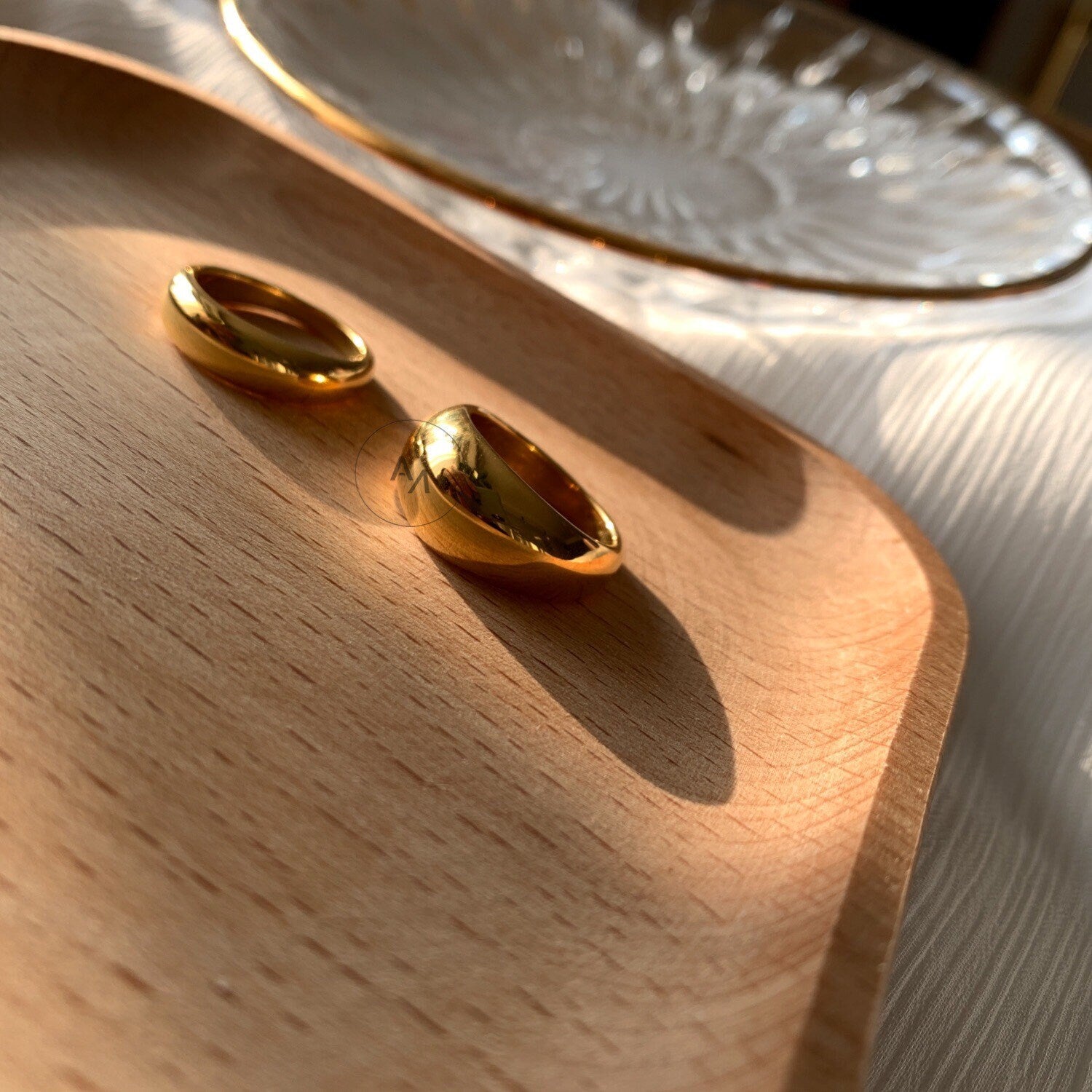 Comparison of slim and thick gold dome ring silhouettes in mirror finish