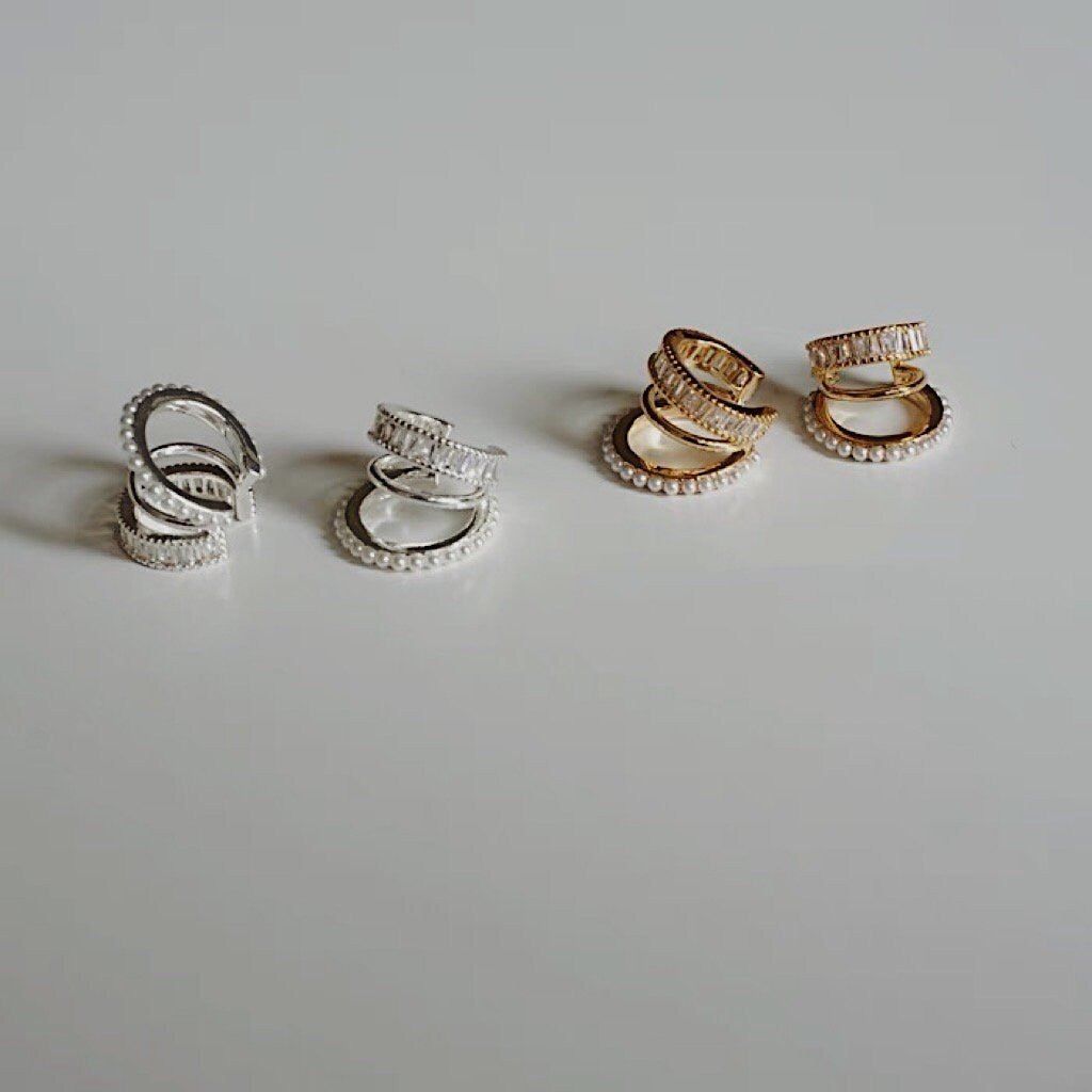 Luxe Triple Ear Cuff in gold and silver on a white surface showing high-polish finish.