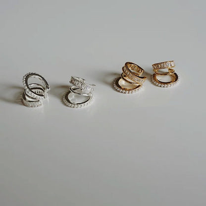Luxe Triple Ear Cuff in gold and silver on a white surface showing high-polish finish.