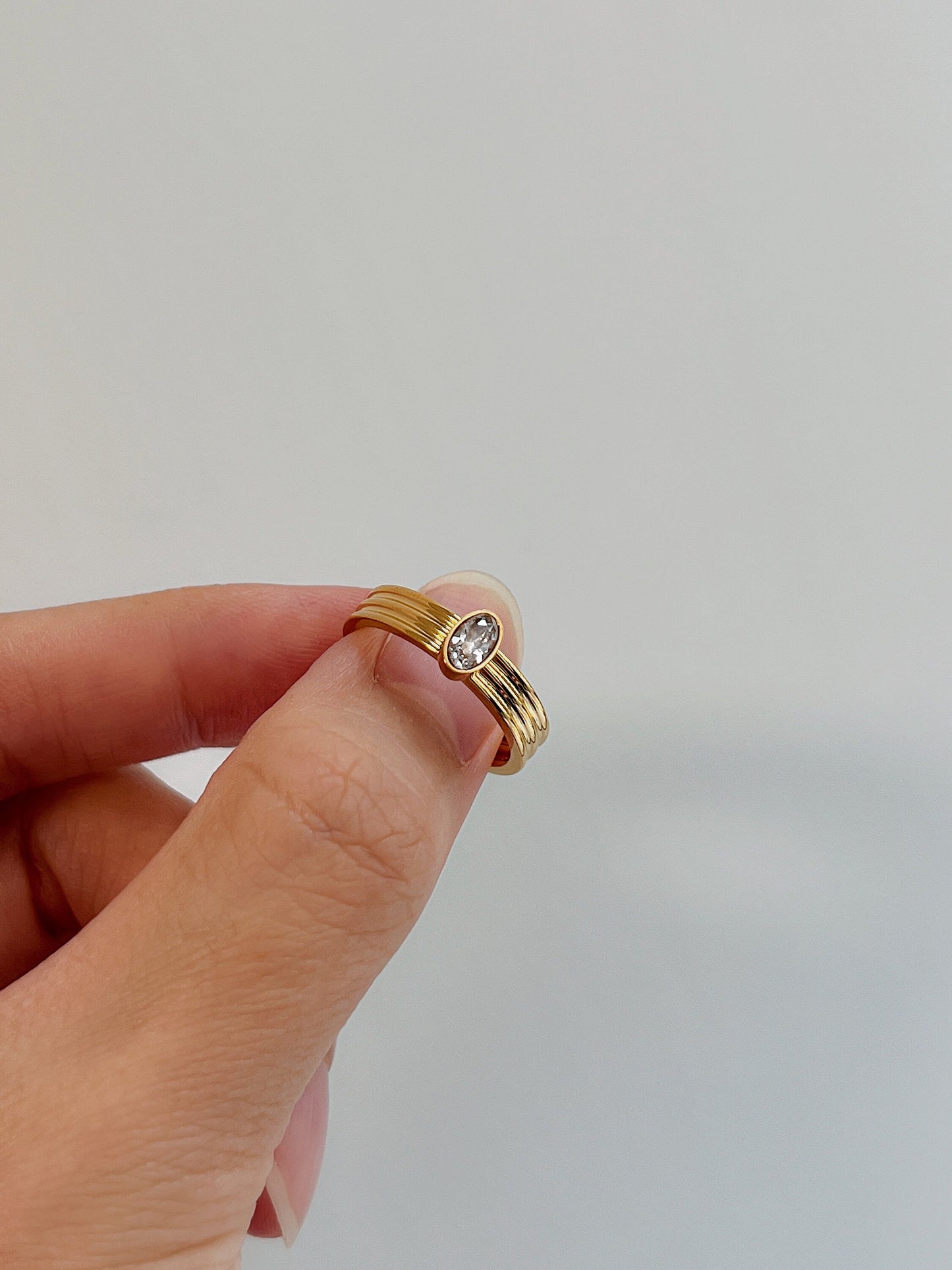 Hand-set 5A cubic zirconia on gold ribbed ring showing brilliance