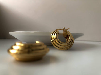 Minimalist gold hoop earrings displayed on a white plate, ideal for gifting and daily use