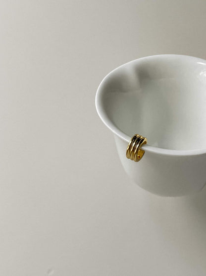 Sculptural triple-tier gold ear wrap for unpierced ears showcasing ribbed texture.