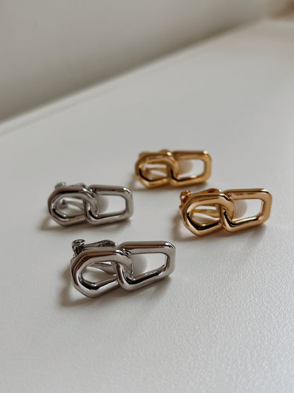 Close-up detail of the hinged lever clip mechanism fitted with a white non-slip silicone sleeve cushion on a non-pierced gold link earring.