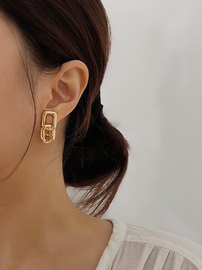 Profile view of an unpierced earlobe holding a gold link clip-on earring securely with a discreet silicone sleeve backing.