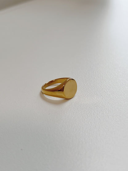 Close up of tapered gold signet ring highlighting the flat face
