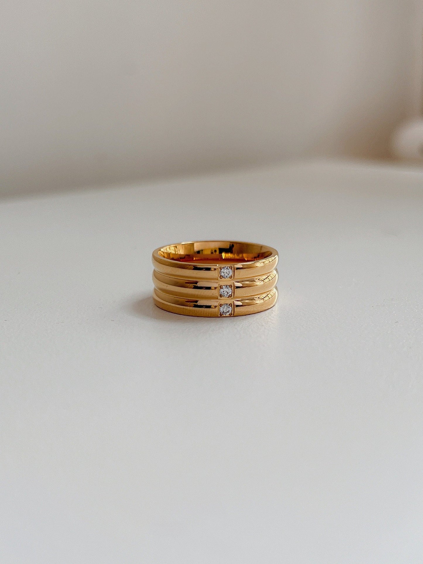 Close up of architectural ribbed texture on gold wide statement ring