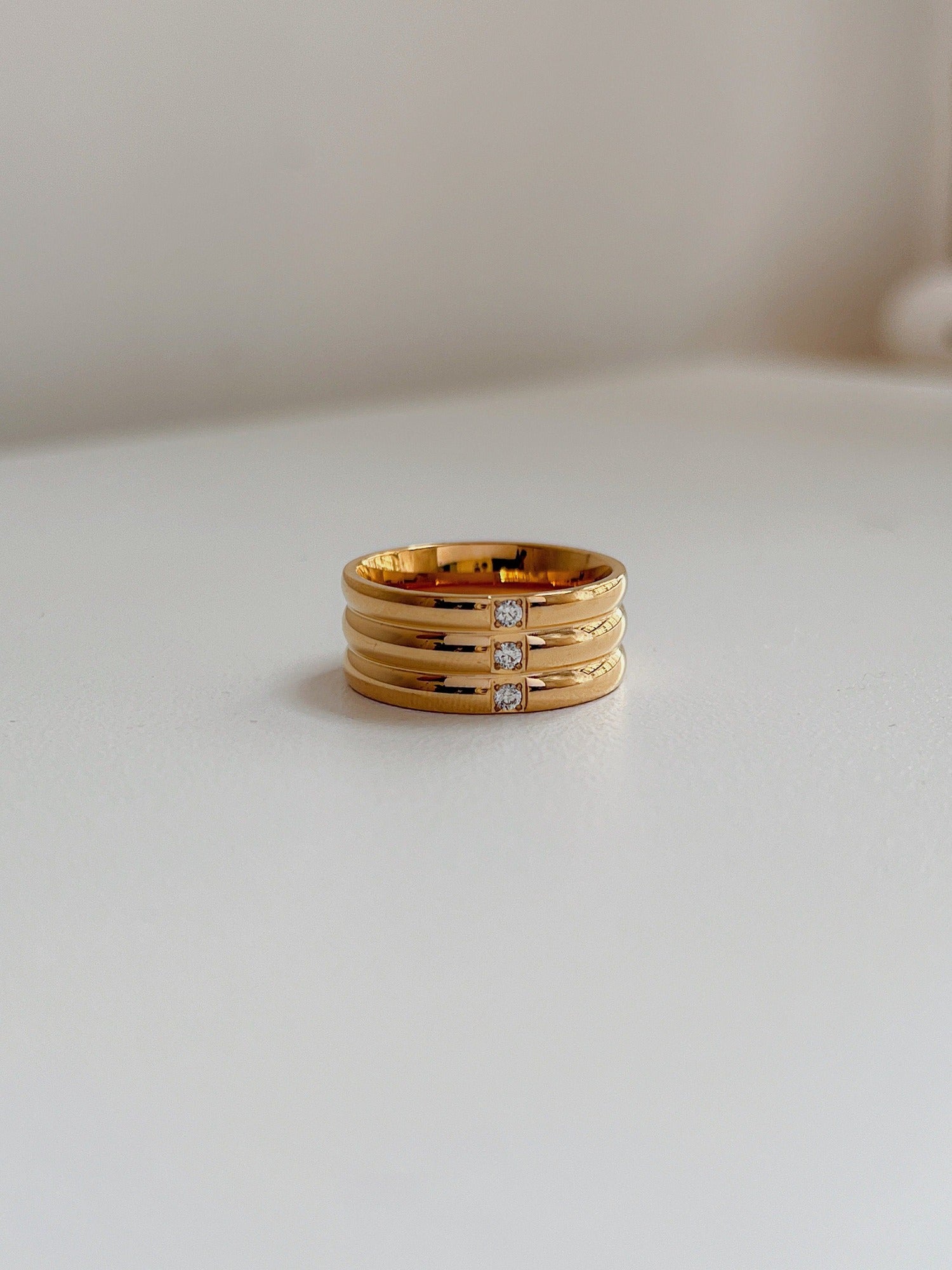 Close up of architectural ribbed texture on gold wide statement ring