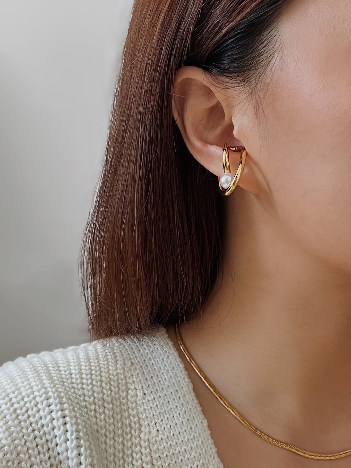 Close-up profile of model styling the Karolina Cuff on the earlobe