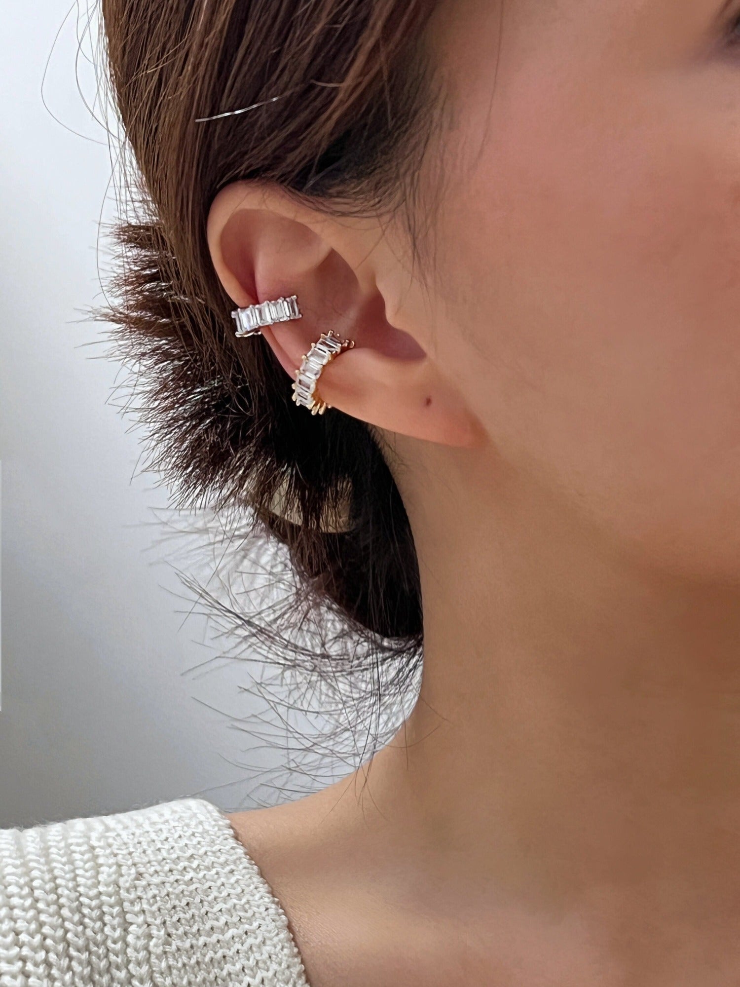Quiet luxury ear curation on a model featuring the Aria 18K gold PVD cuff.