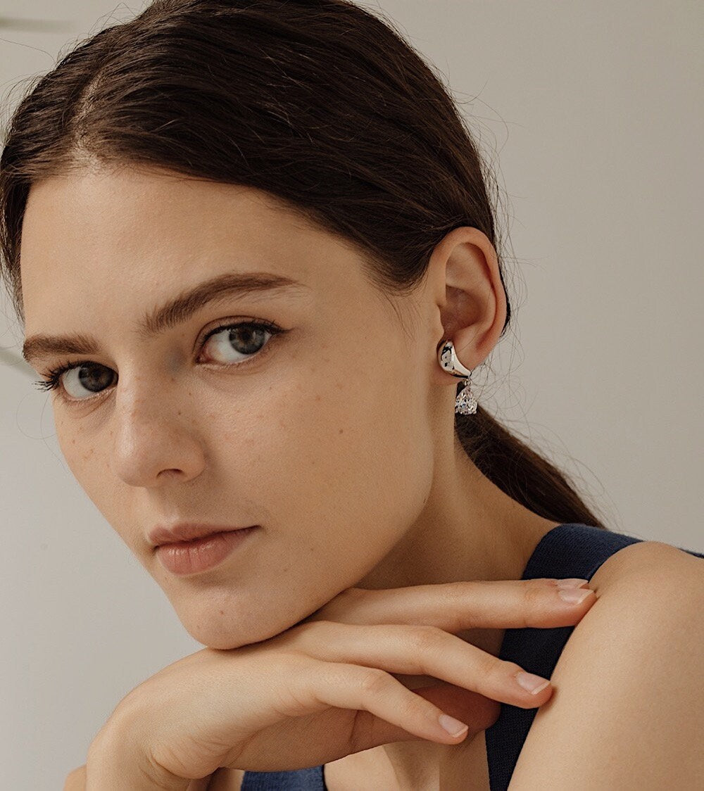 Close-up of non-pierced lobe cuff earrings fits on model's ear lobe.