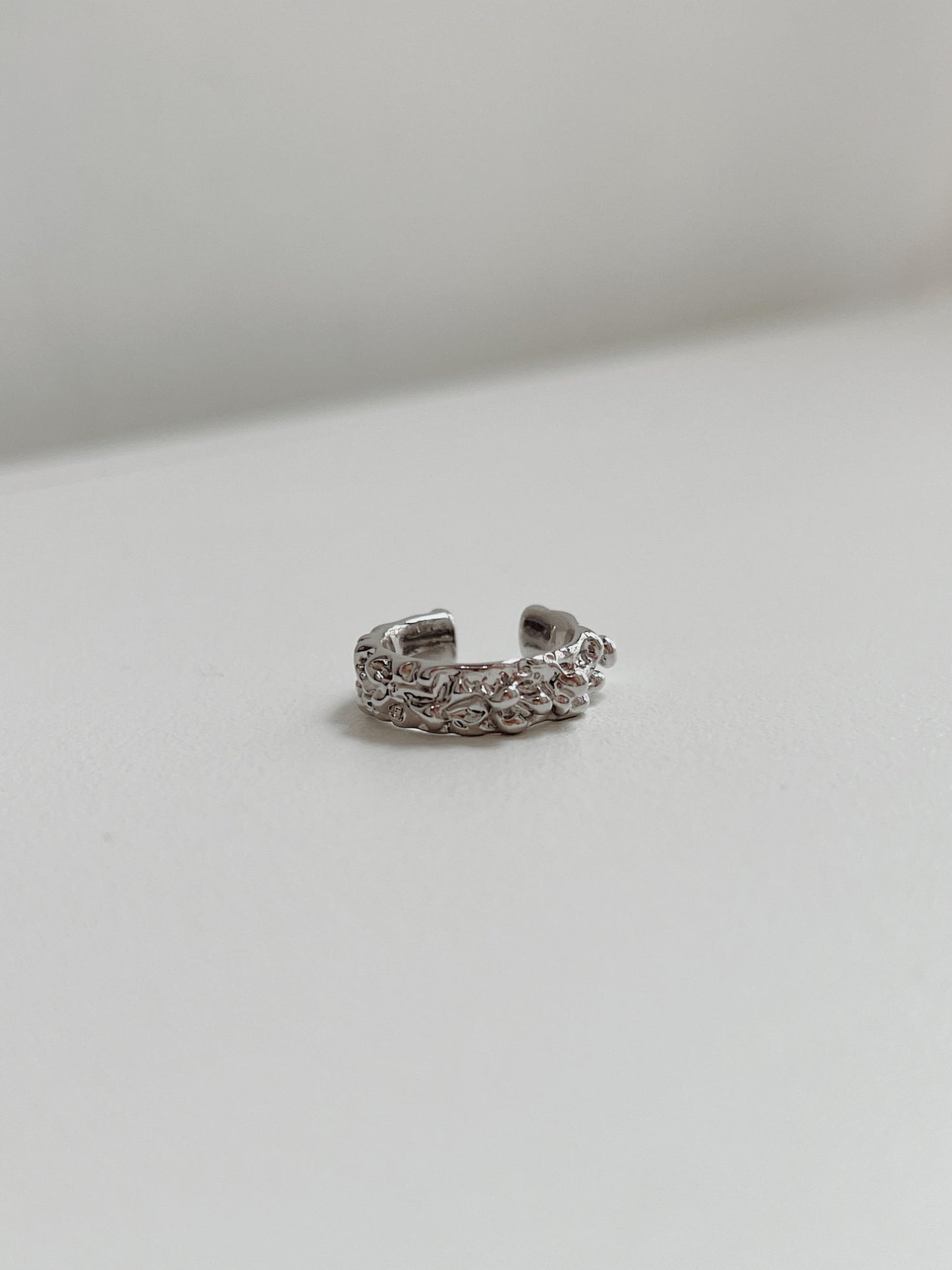Detail view showing the architectural, wide-band silhouette of the Silver Molten Ridge ear cuff.
