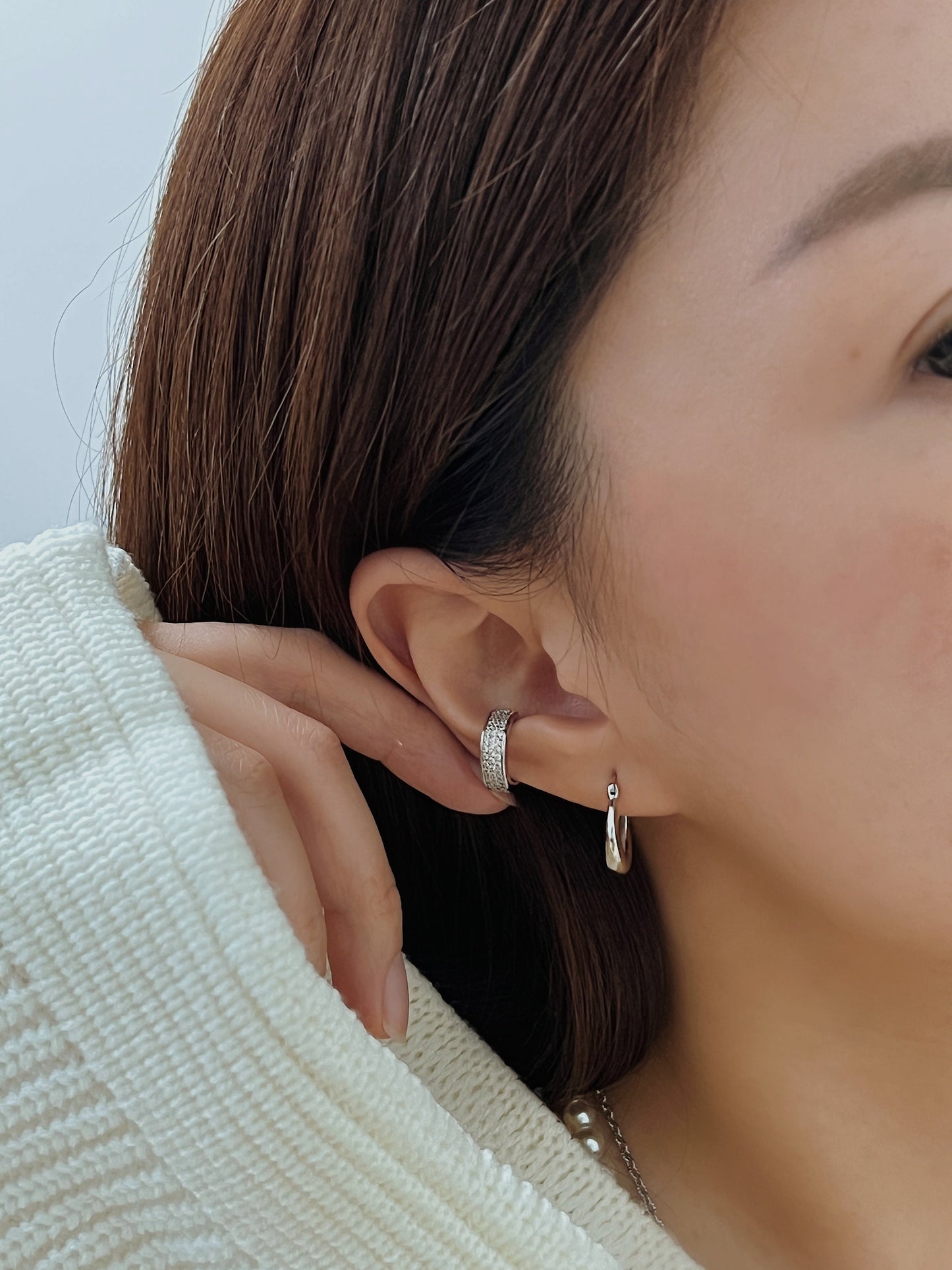 Model wearing Priscilla silver Ear Cuff with minimalist silver hoops.