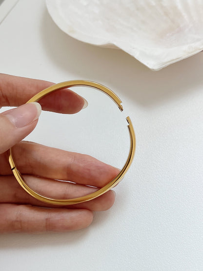 High-resolution detail of the calibrated internal hinge mechanism on the 18K gold Jayden curved bangle.