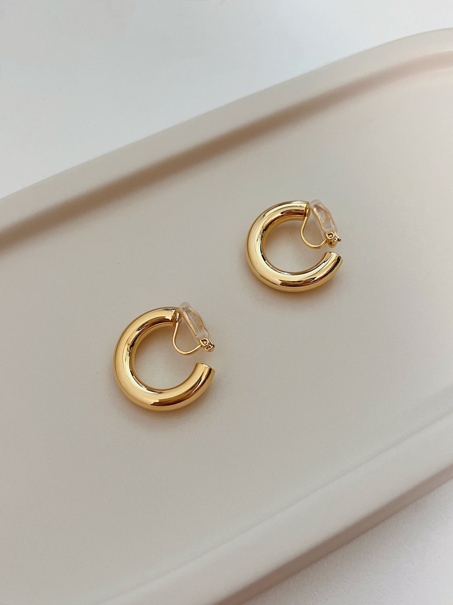 Independent atelier luxury clip earrings showcasing smooth rounded edges and hollow lightweight frame