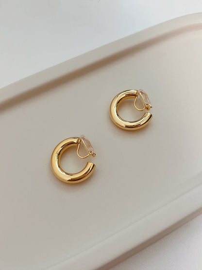 Independent atelier luxury clip earrings showcasing smooth rounded edges and hollow lightweight frame