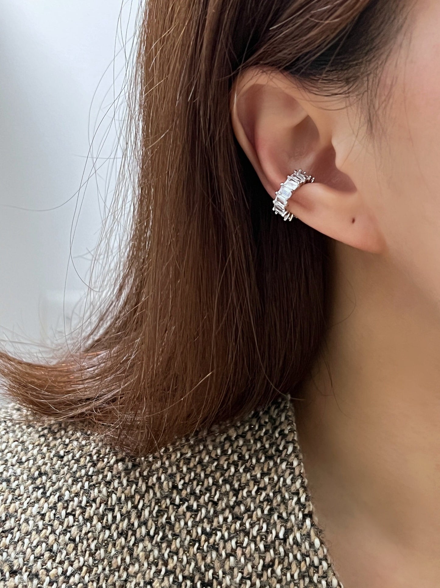 Side profile of a model featuring a curated ear stack with waterproof silver cz ear cuff.
