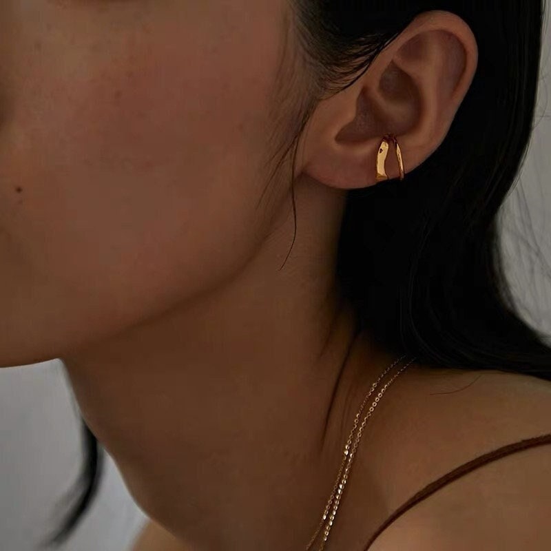 Model wearing Beverly gold double cuff in the conch for a structured look.