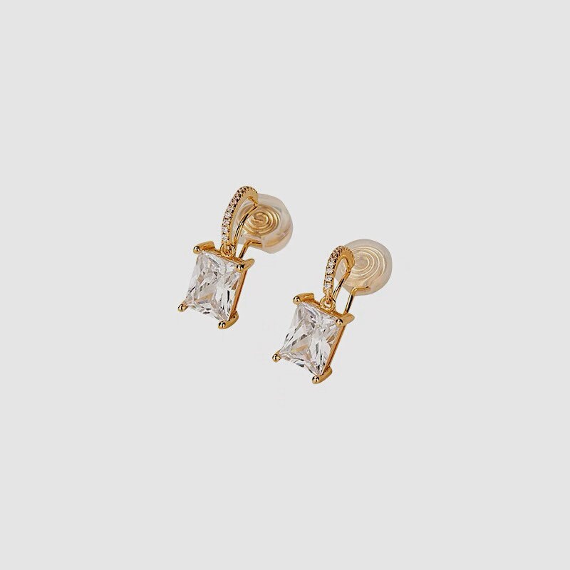 Angled shot showing open silicone pad clip backing on 14k gold plated brass frame