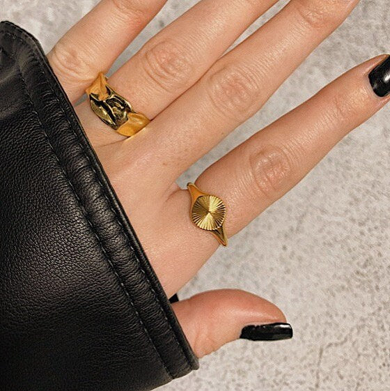UK fashion blogger wearing gold sun signet ring with statement band with leather jacket