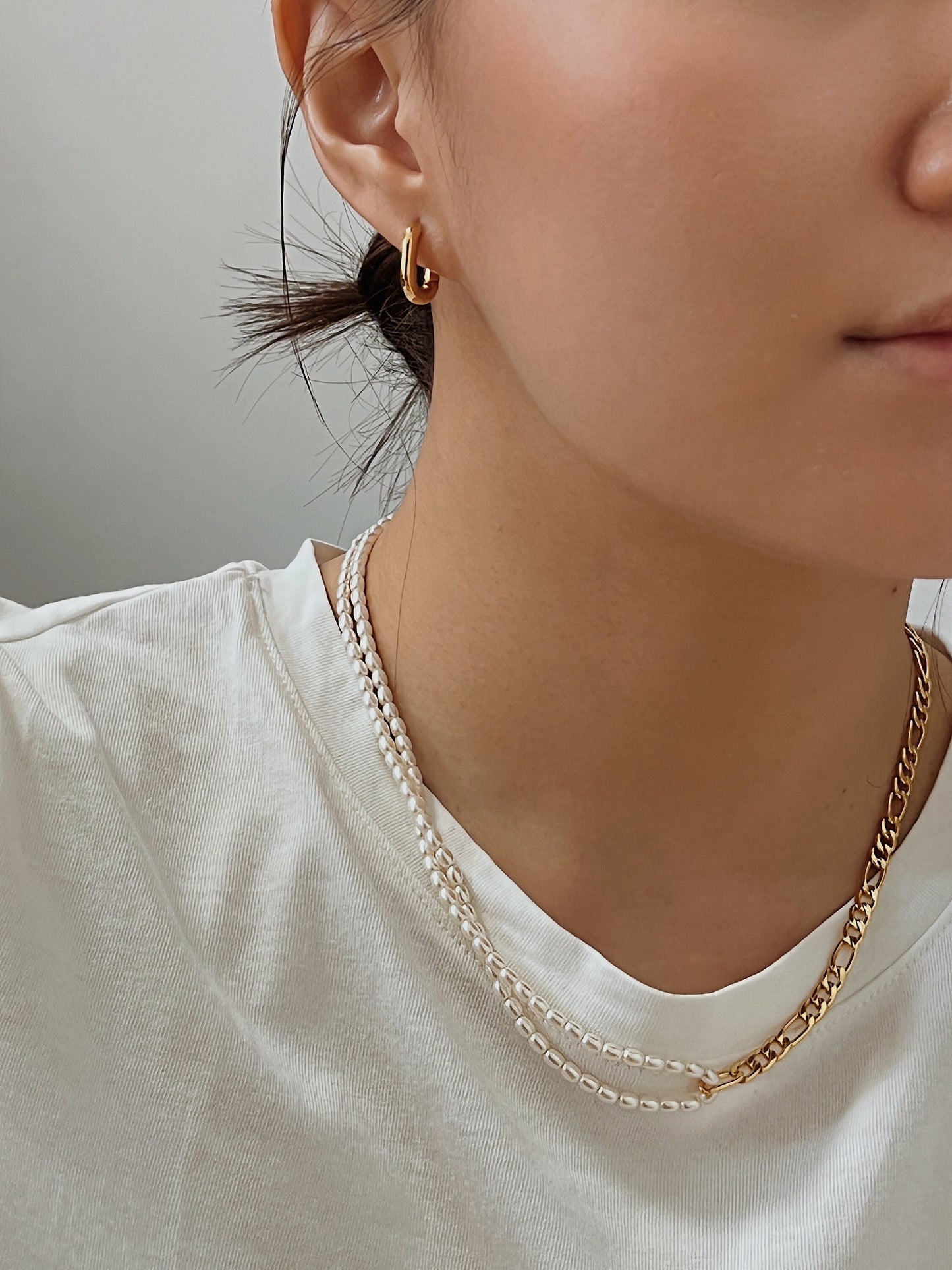 Casual chic styling showcasing a pre layered necklace look with a figaro chain