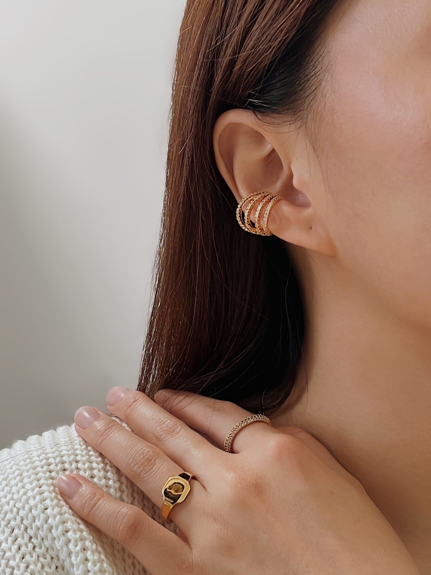 Model showcasing Aurelia 4-layer cuff with minimalist stacking rings.
