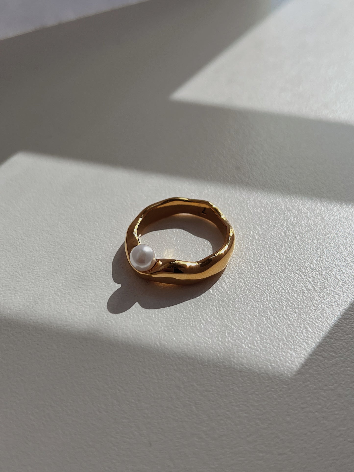 Understated luxury jewellery design featuring an asymmetrical pearl setting.