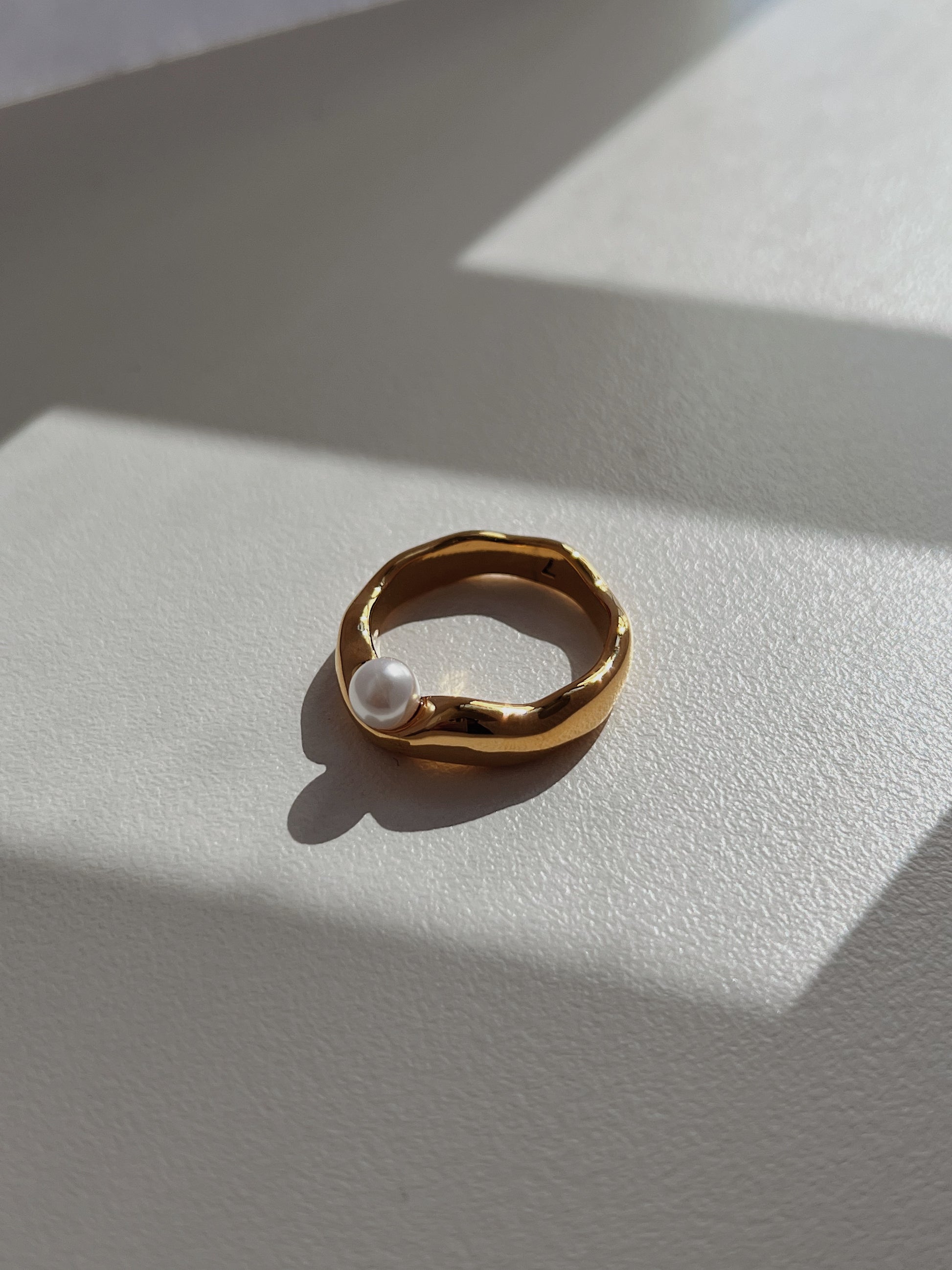 Understated luxury jewellery design featuring an asymmetrical pearl setting.