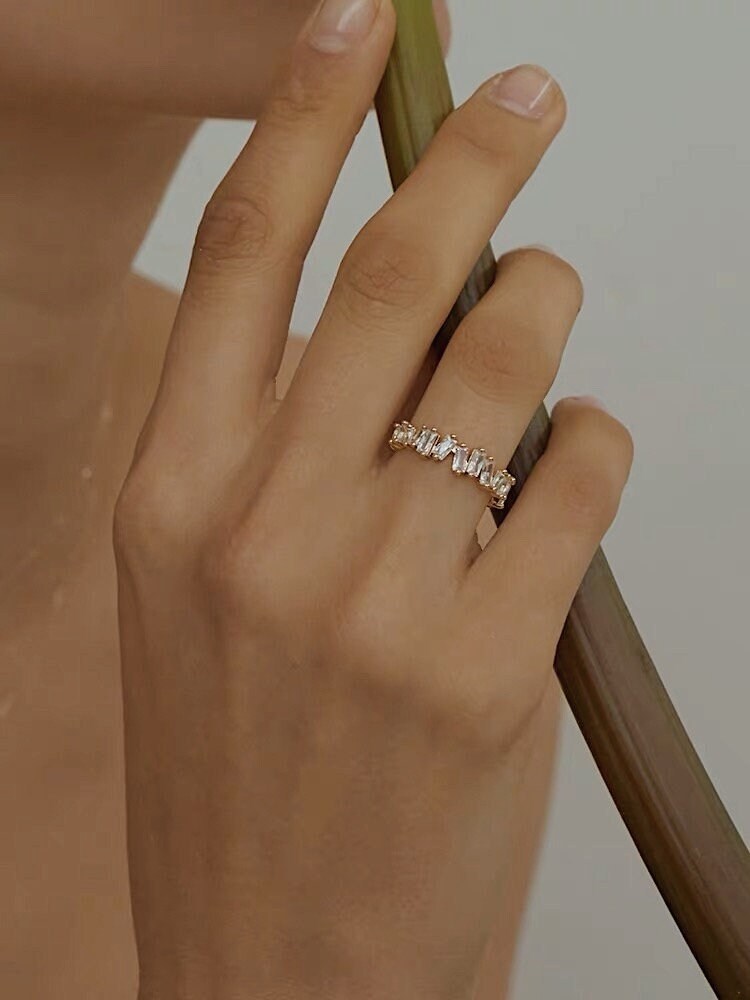 Editorial jewelry shot of model with flower wearing a gold CZ ring