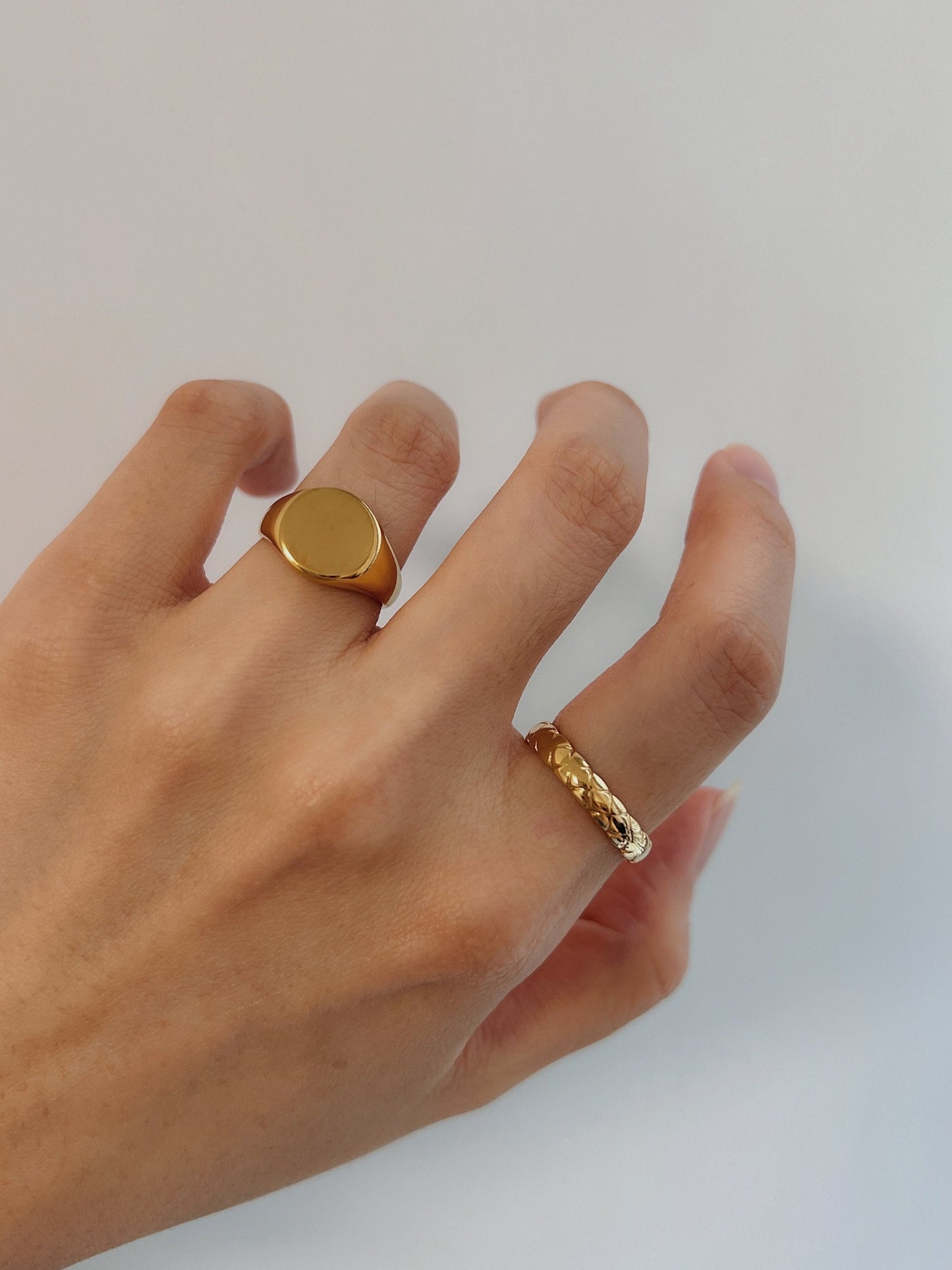 Hand styling a bold unisex gold signet ring with a slim quilted band ring