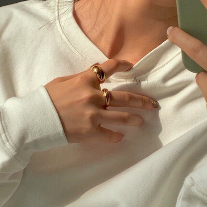 Close up of hand styling gold dome rings for a minimal stack