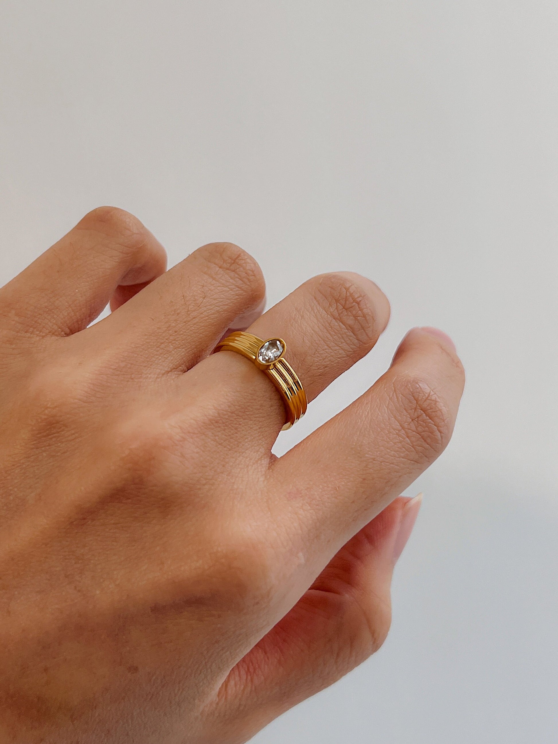 Hand model wearing Poppi ribbed oval ring on the middle finger