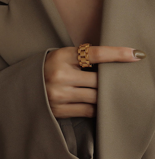 Hand model wearing Veneti gold watch chain ring on index finger