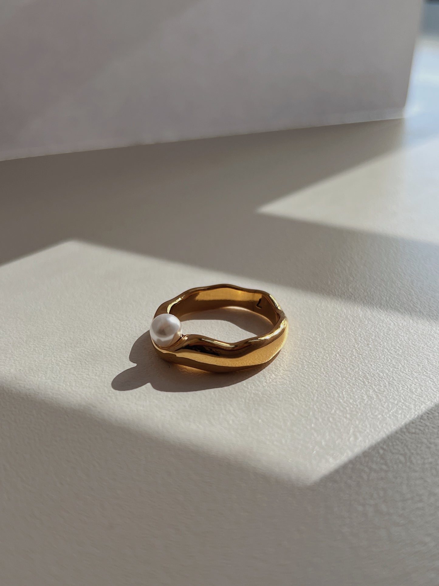 Delicate statement pearl ring displaying organic contours and high polish finish.