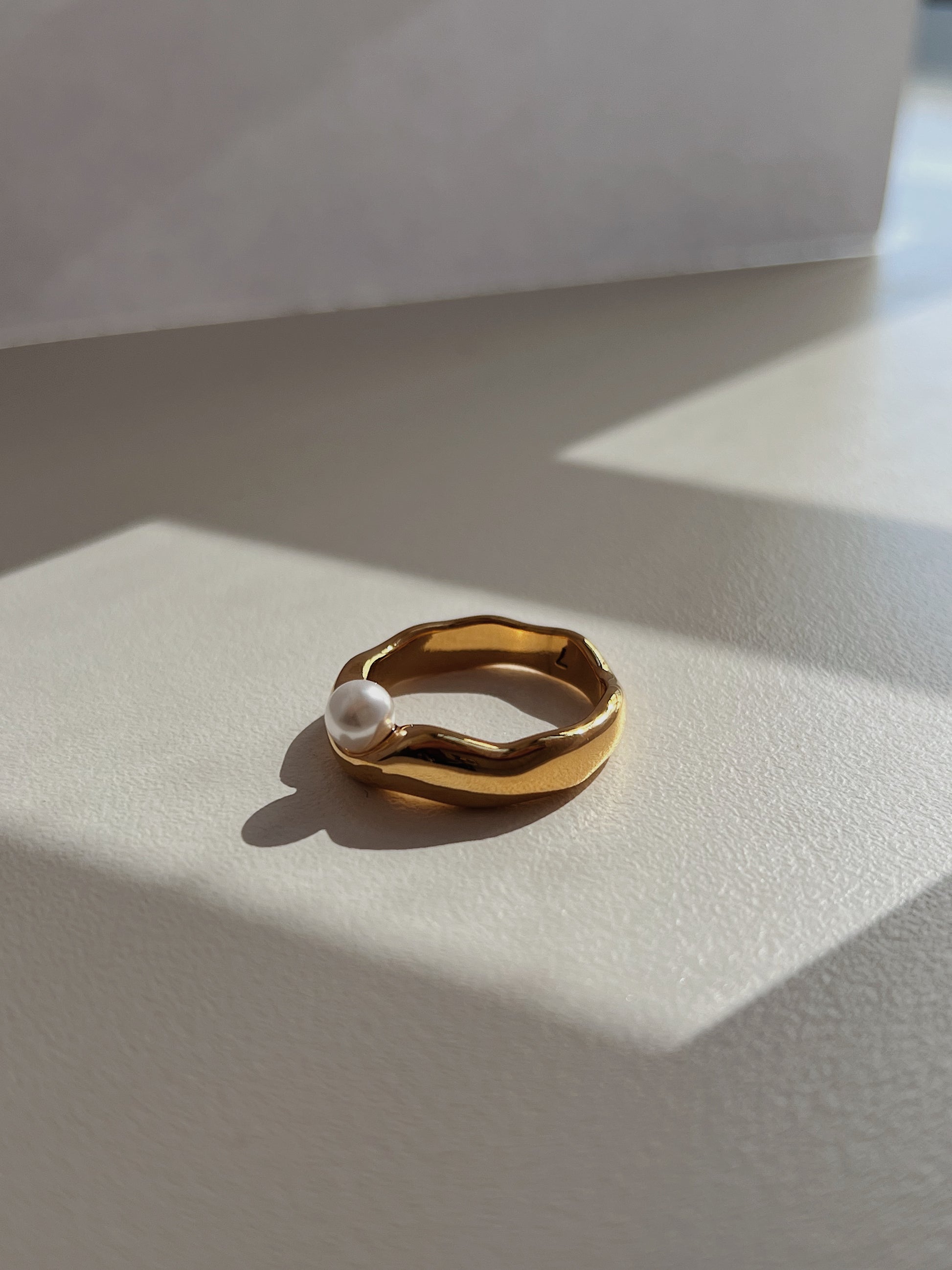 Delicate statement pearl ring displaying organic contours and high polish finish.