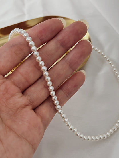 Contemporary luxury statement choker featuring small row of natural pearls catching light