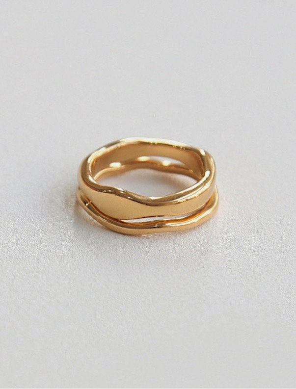 Modern stackable wavy rings in think and slim displayed on a clean background.