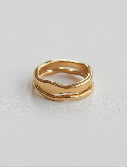 Modern stackable wavy rings in think and slim displayed on a clean background.
