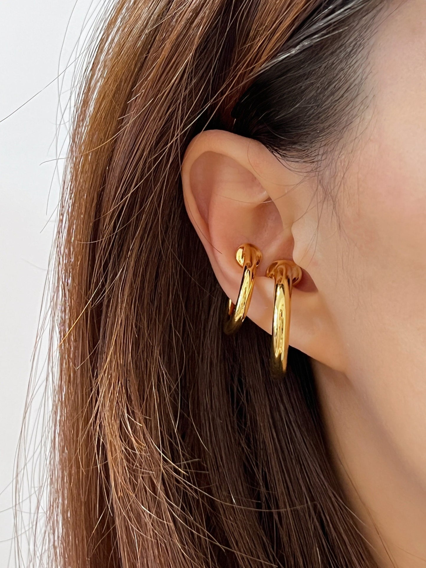 Gold hoop ear cuff earring on model, highlighting fashionable accessory for jewelry lovers.