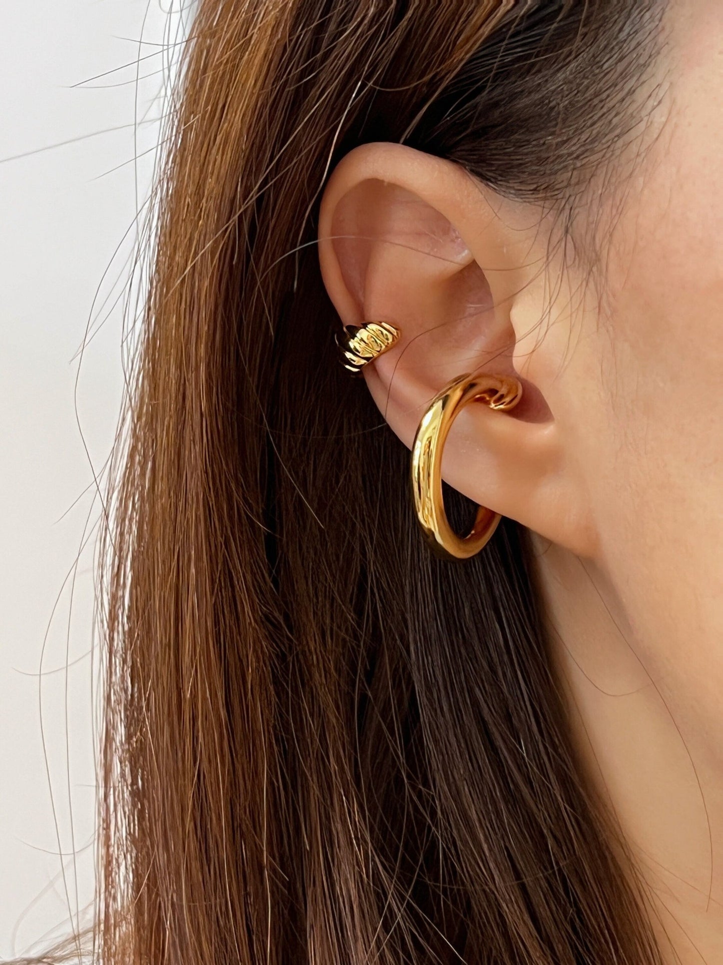 Elegant gold ear cuff earring on model with brown hair, perfect for stylish jewelry enthusiasts