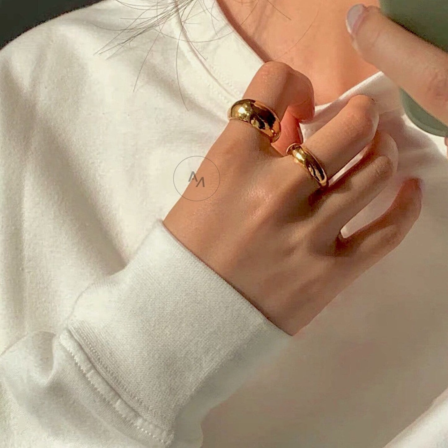Active luxury styling of the Eloise gold ring on a hand model
