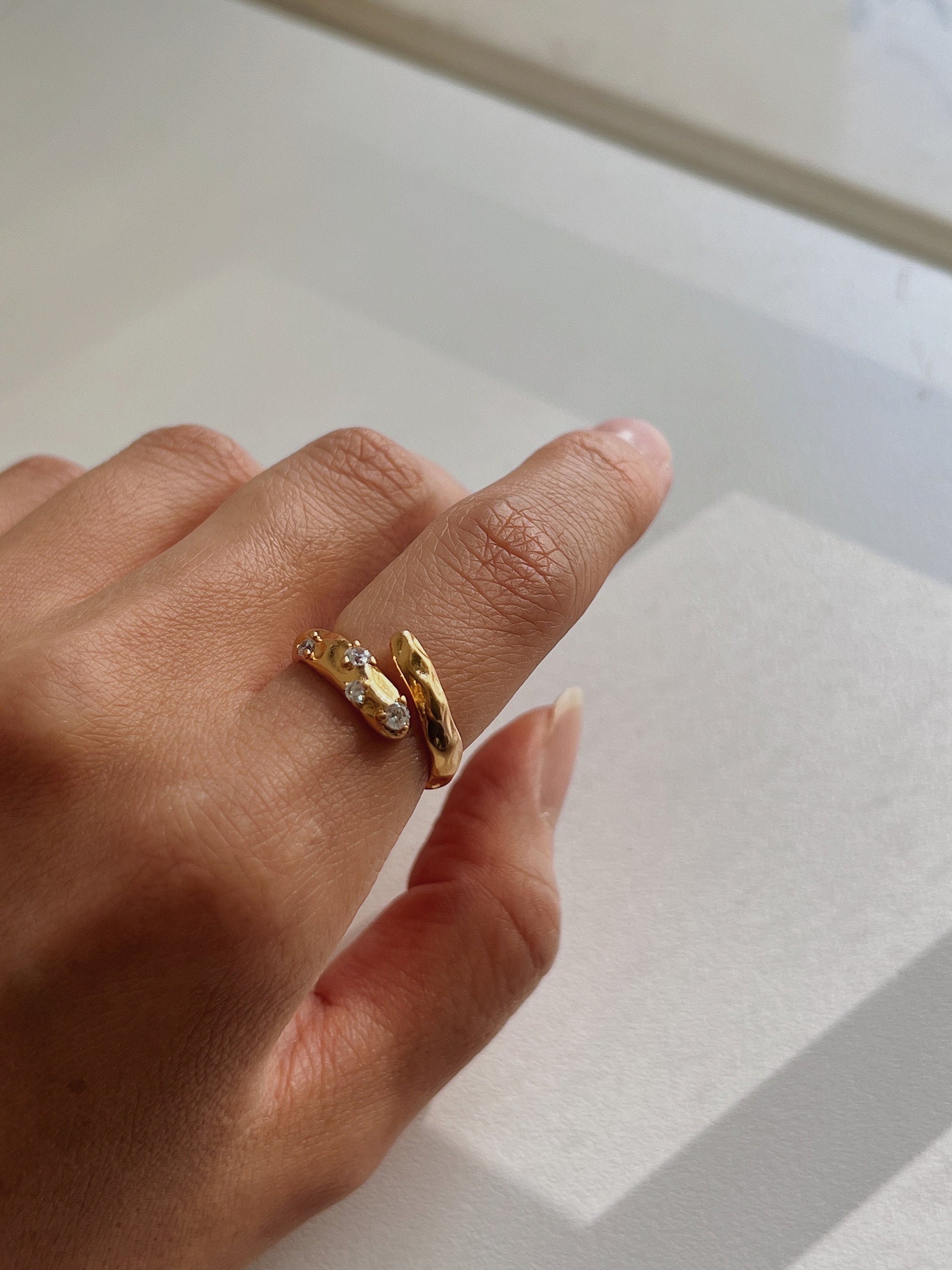 Minimalist hand jewelry shot featuring the Doris ring in natural light