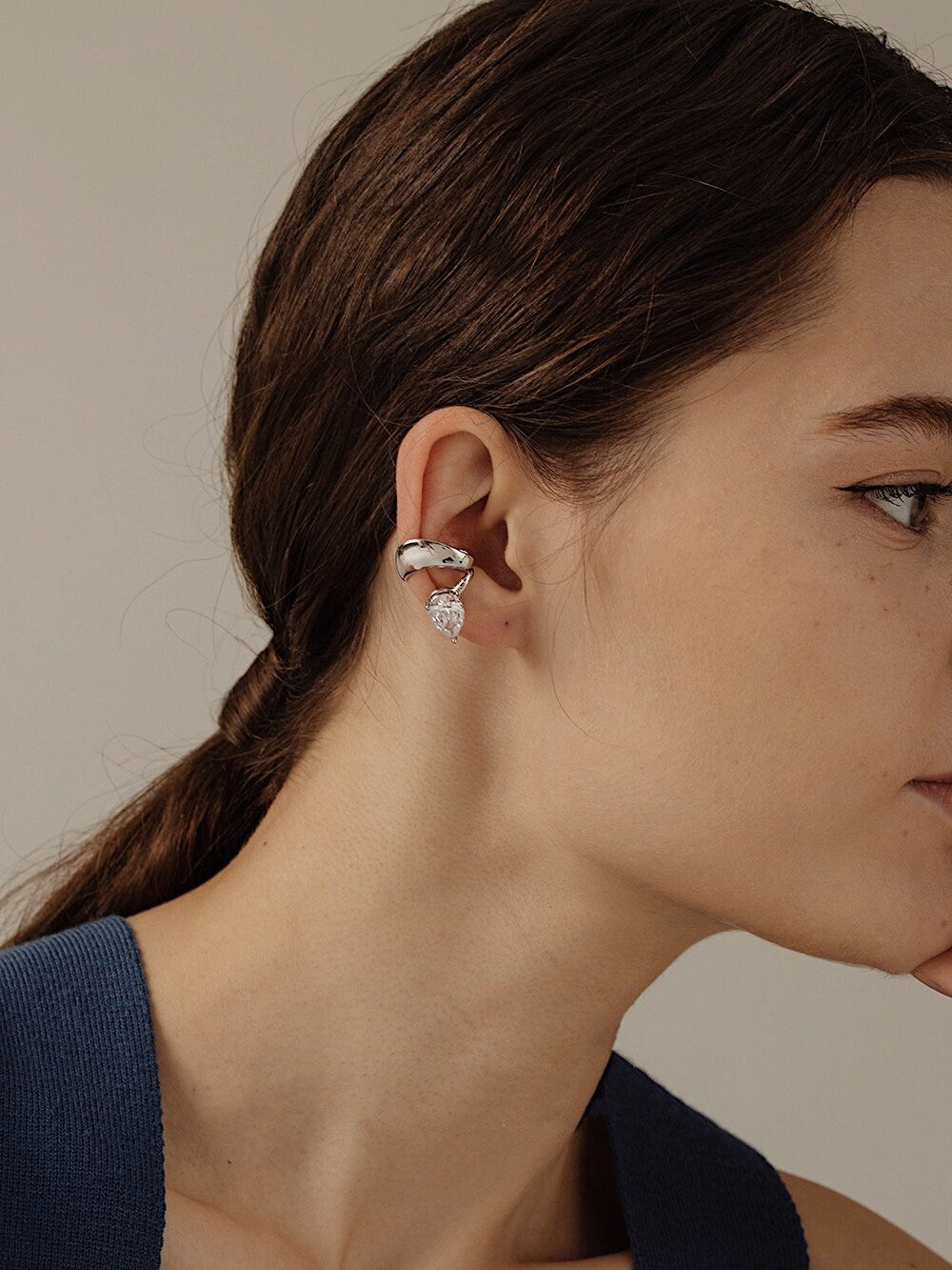 Side profile of Lisa Teardrop Earrings styled with a low pony hair style.