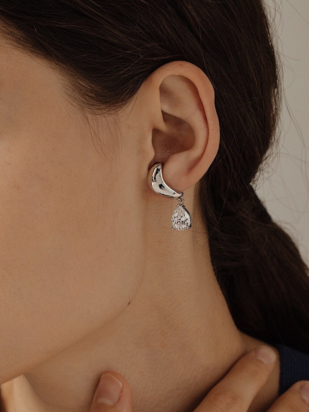 Model wearing Lisa Silver Cuff on ear lobe with low pony hair.