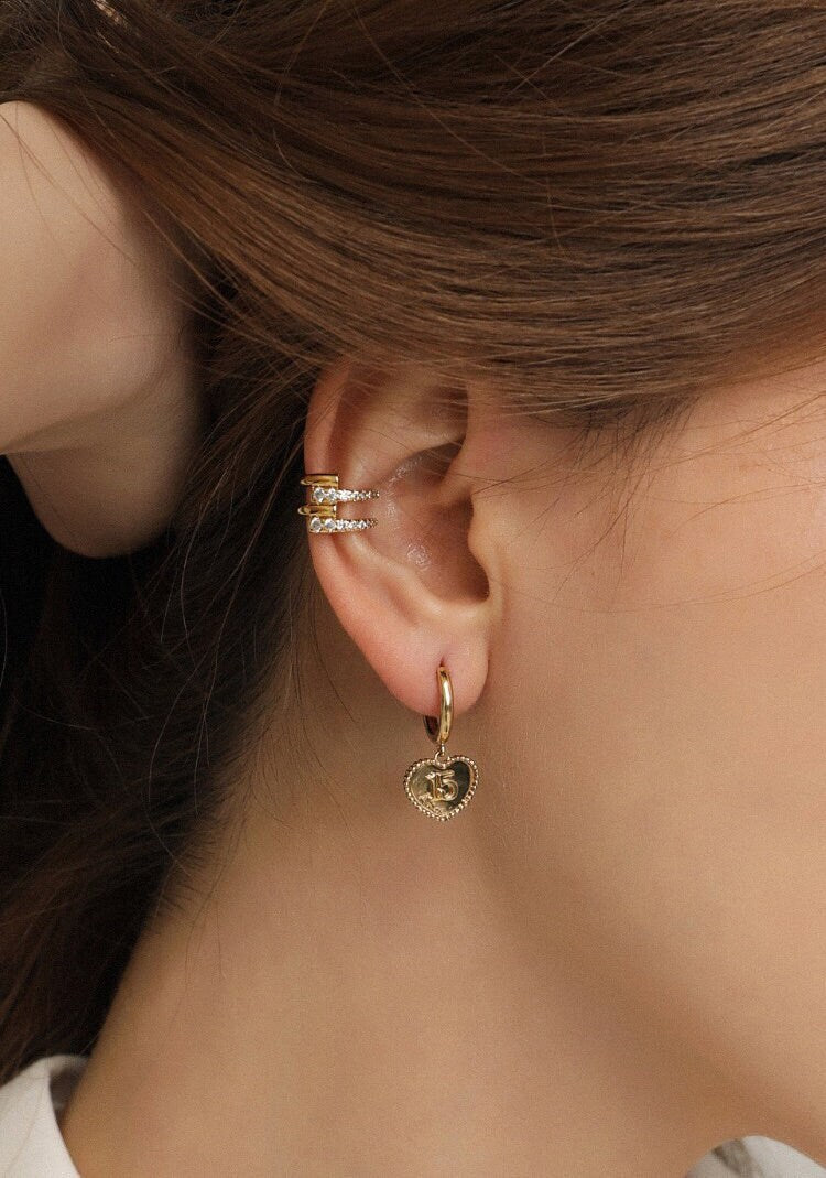 Quiet luxury ear stack on a model featuring the Mandy 18K gold PVD cuff.