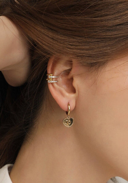 Quiet luxury ear stack on a model featuring the Mandy 18K gold PVD cuff.